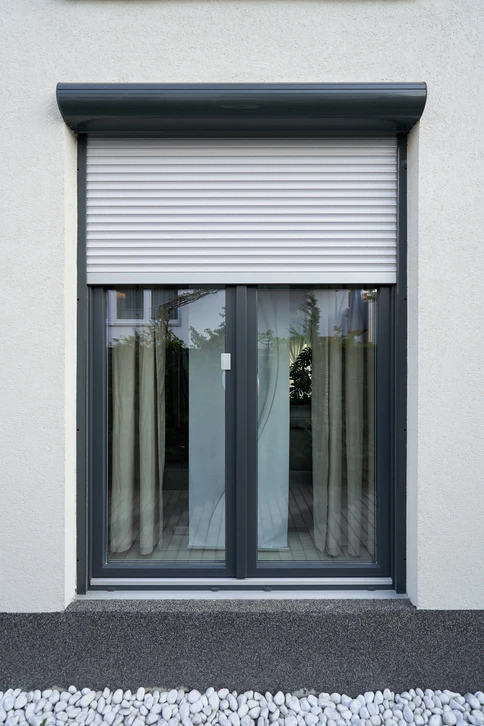 Fa&ccedil;ade ext&eacute;rieure d'un b&acirc;timent moderne avec porte-fen&ecirc;tre &agrave; deux vantaux et volet roulant &eacute;lectrique