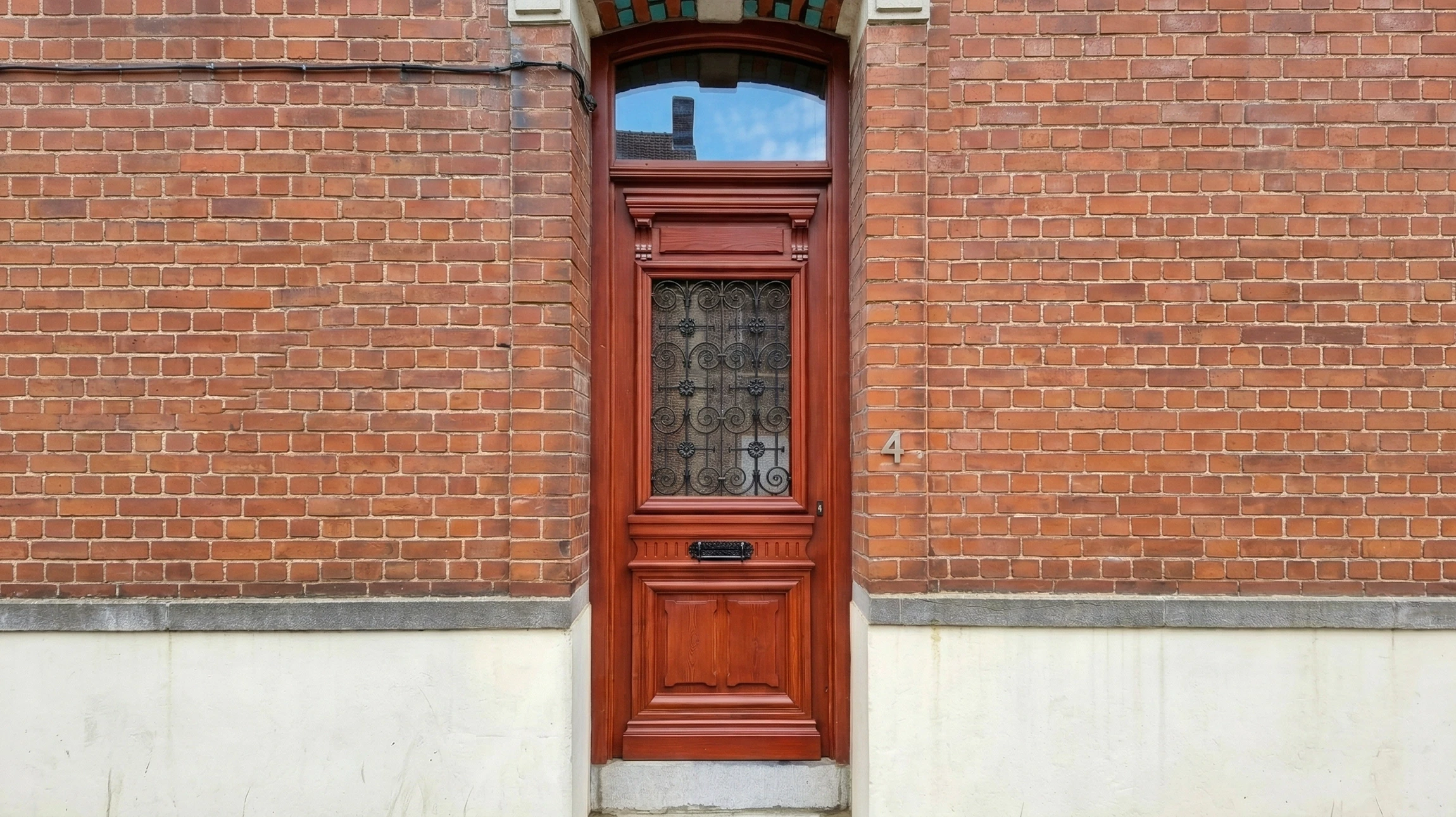 Façade extérieure d'une maison alsacienne traditionnelle à colombages avec murs roses et poutres apparentes en bois foncé